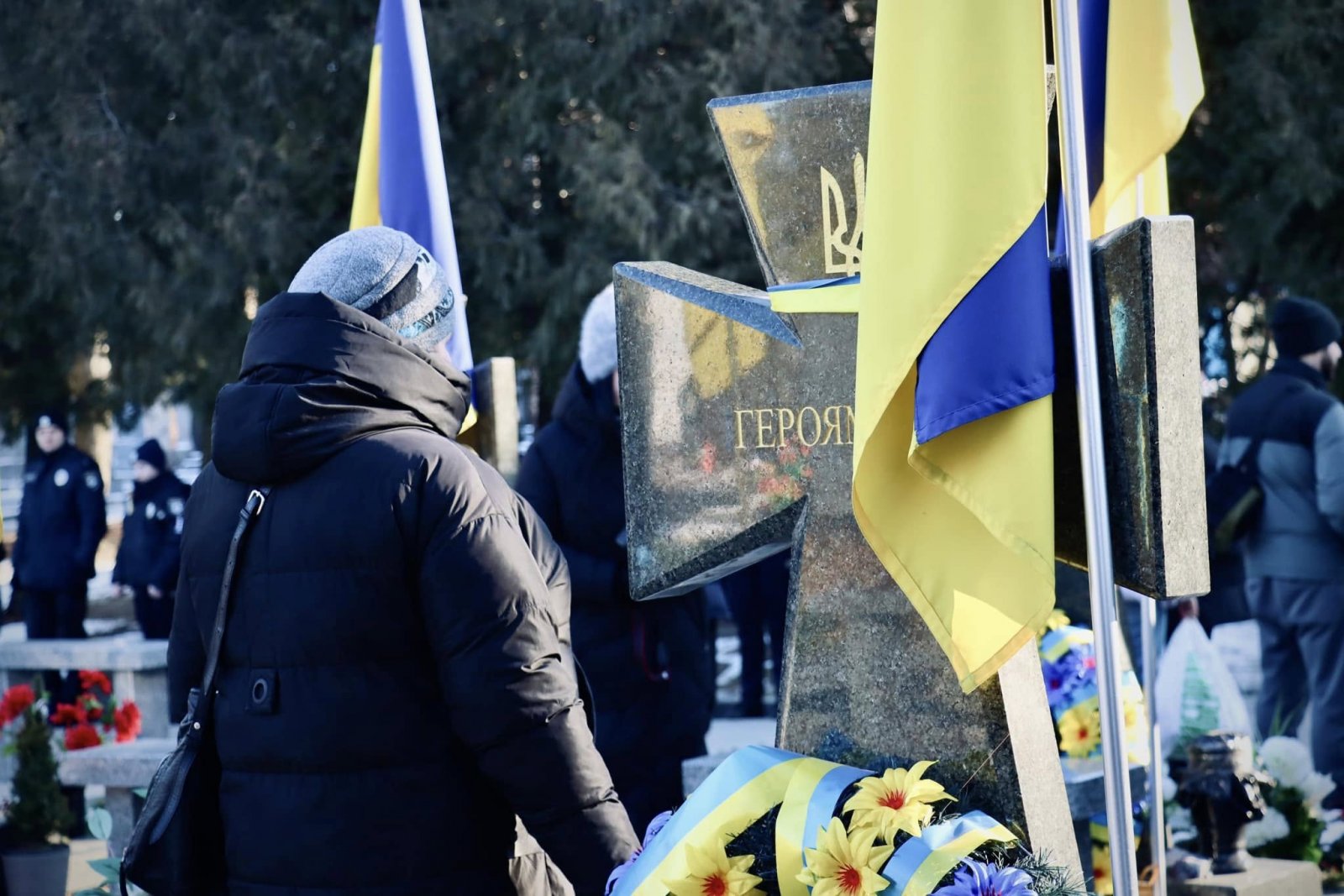 Жінка стоїть перед могилою загиблого героя.